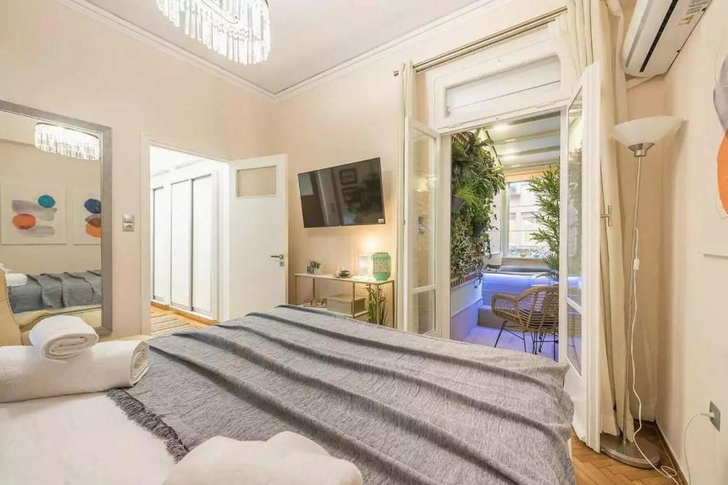 a bedroom with a large bed and a living room at Elegant Escape Kolonaki in Athens