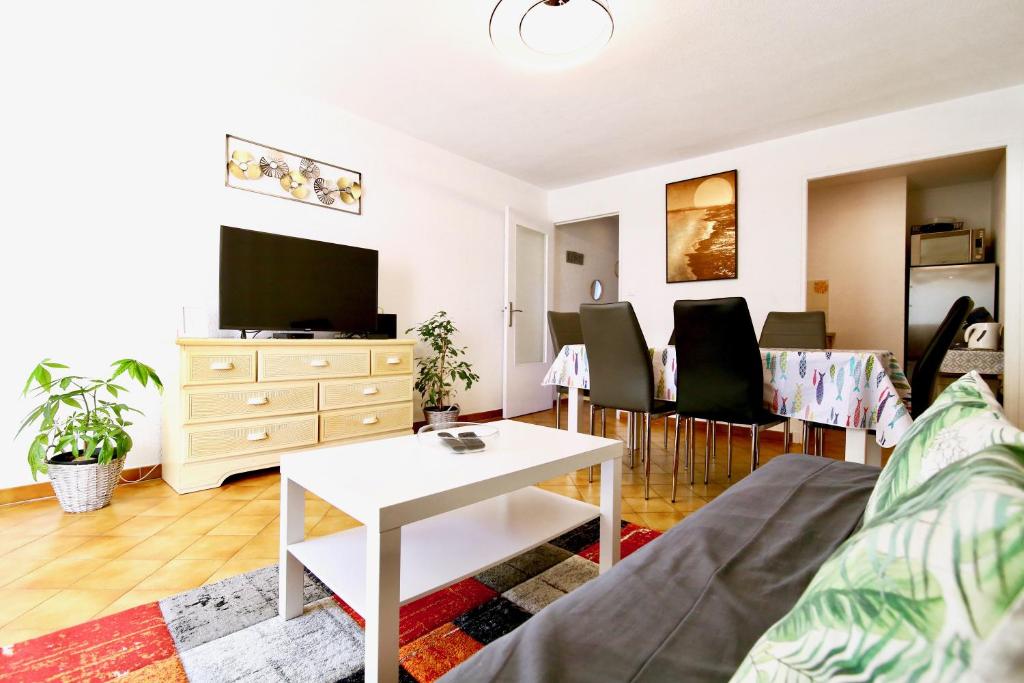 un salon avec un canapé et une table dans l'établissement CAPRI Appartement confort bord de mer, à Saint-Mandrier-sur-Mer