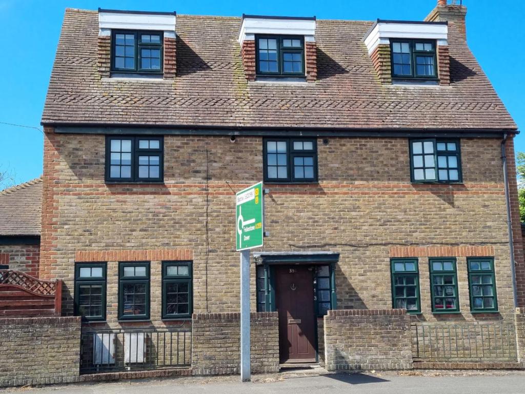 ライにあるRiver View - Stunning Garden Flat w Free Parking Pass The Keysの目の前の看板が立つレンガ造り