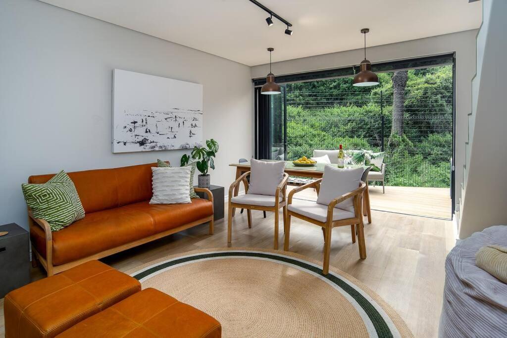 a living room with a couch and a table at Wild Sage - Wilderness Cottage in Wilderness