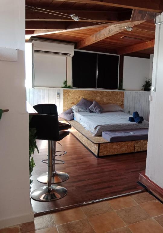 a bedroom with a bed and a desk and a chair at El Escondite Perfecto in Benacazón