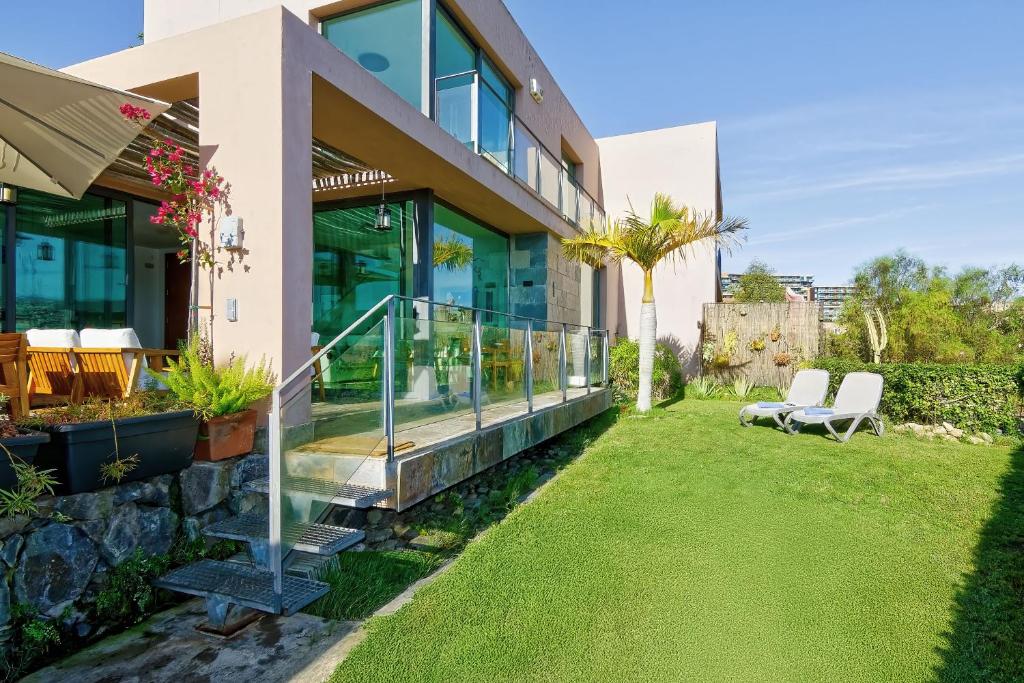 a house with a green lawn in front of it at Holiday Home Villa Gema in Maspalomas