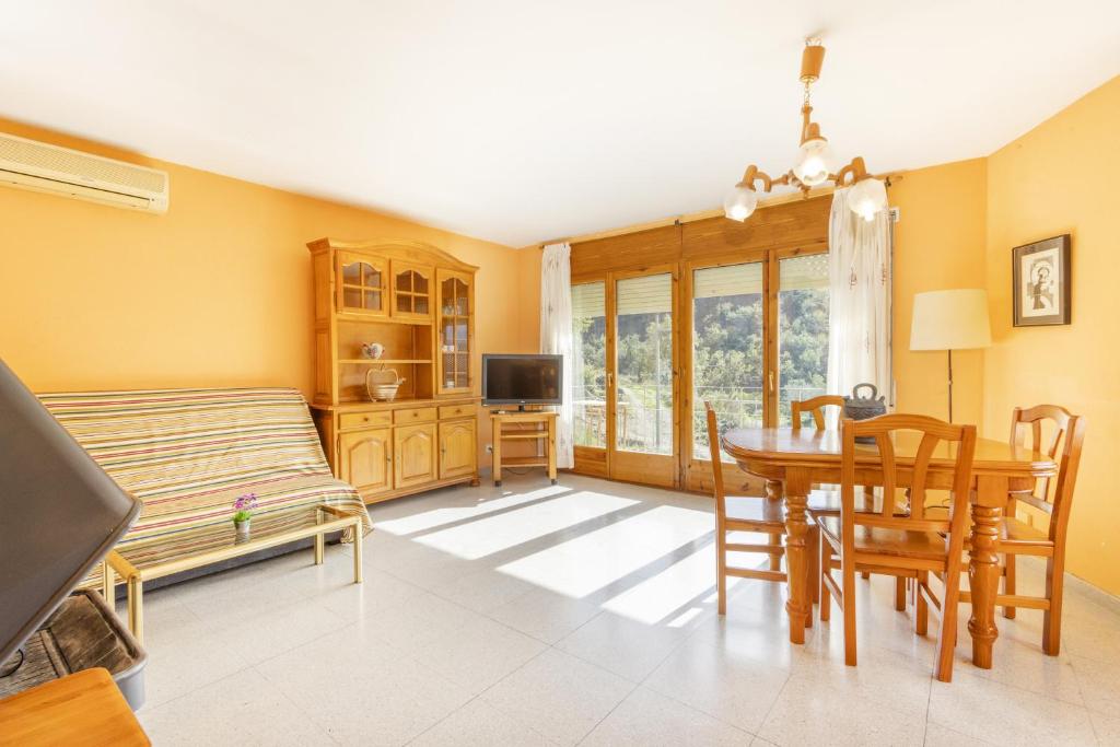 a living room with a dining room table and a bedroom at Casa Font Sant Martí de Barcedana in Aransís