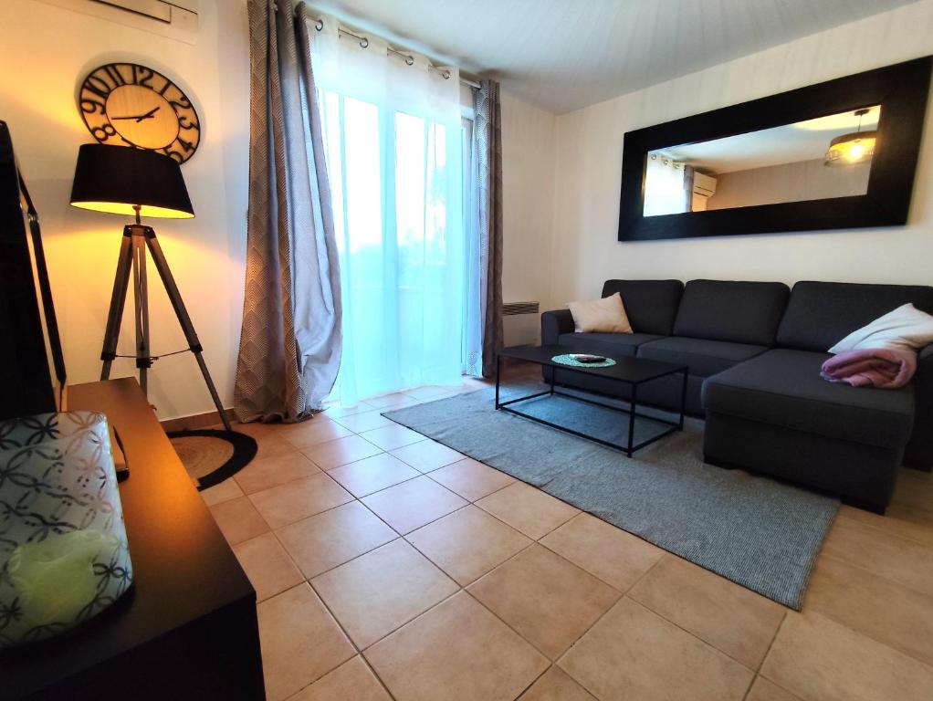 un salon avec un canapé et un miroir dans l'établissement La Noria - Confort et Facilité - Parking, à Aucamville