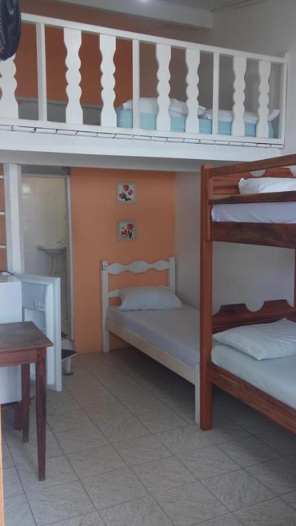 Cette chambre comprend 2 lits superposés et une table. dans l'établissement Hospedagem Casa De Familia, à Parati