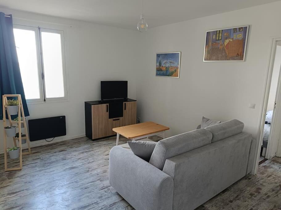 una sala de estar con un sofá y una mesa en Dans la brise du Rhône, en Arles