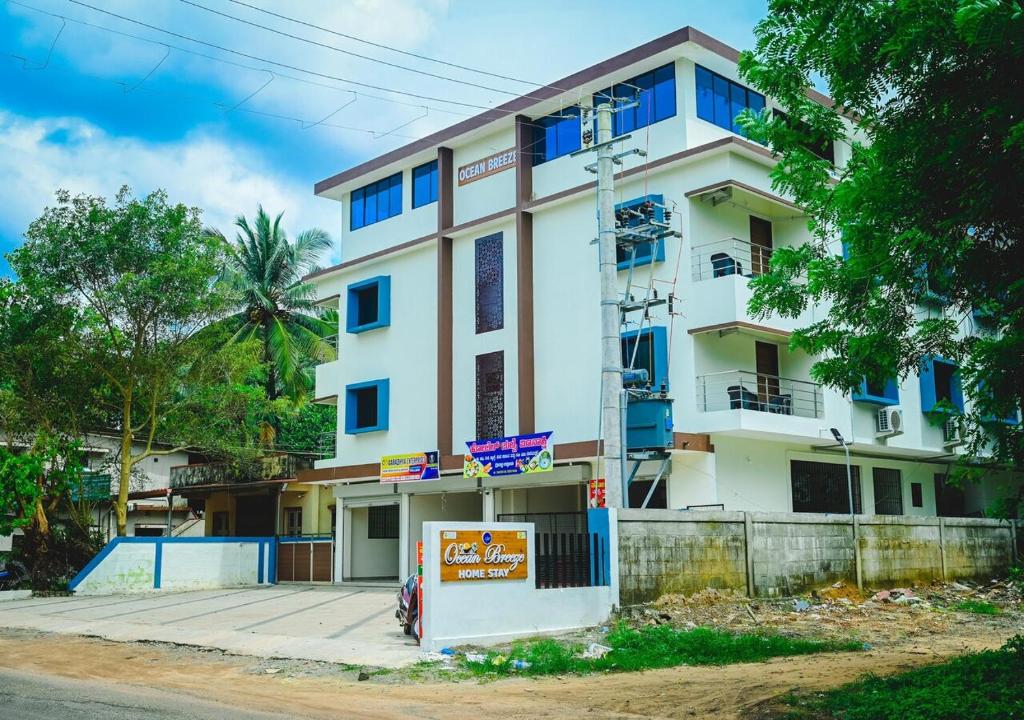Un edificio blanco con un cartel delante. en Ocean breeze, en Udupi