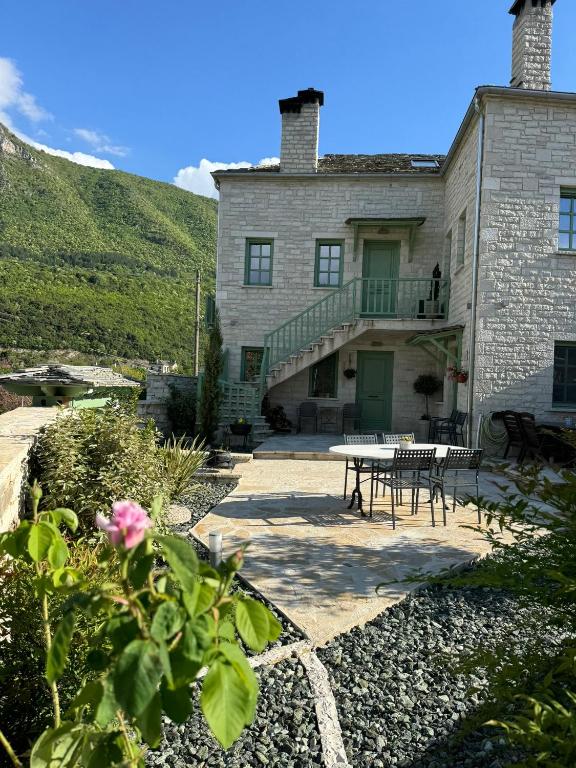 a large stone house with a table and a patio at Aristi boutique stonehouse with attic in Aristi