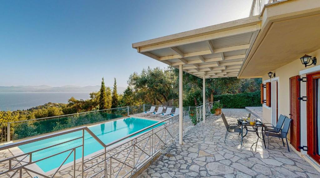 a house with a swimming pool and a patio at Villa Milou in Kagkátika