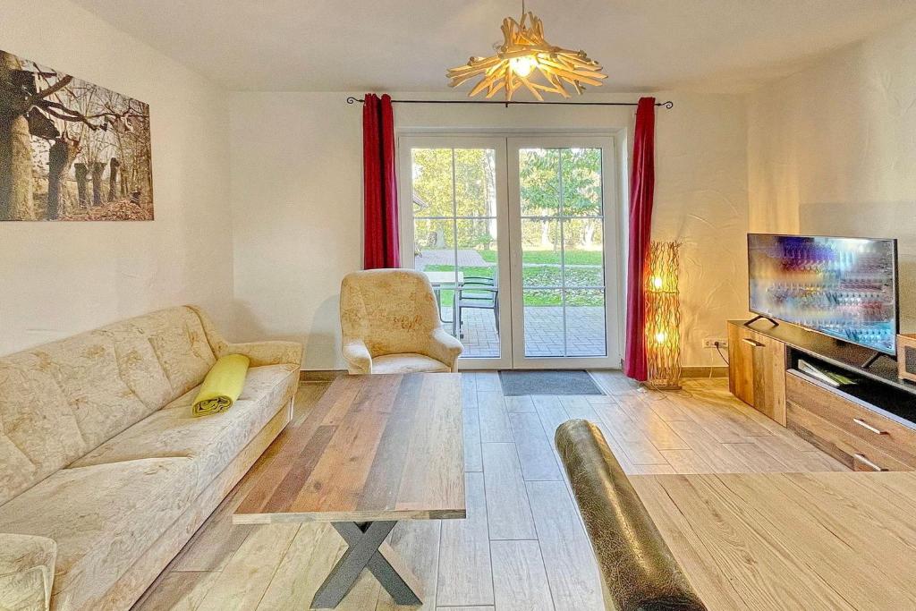 a living room with a couch and a tv at Blockhaus Baum 3 in Burg