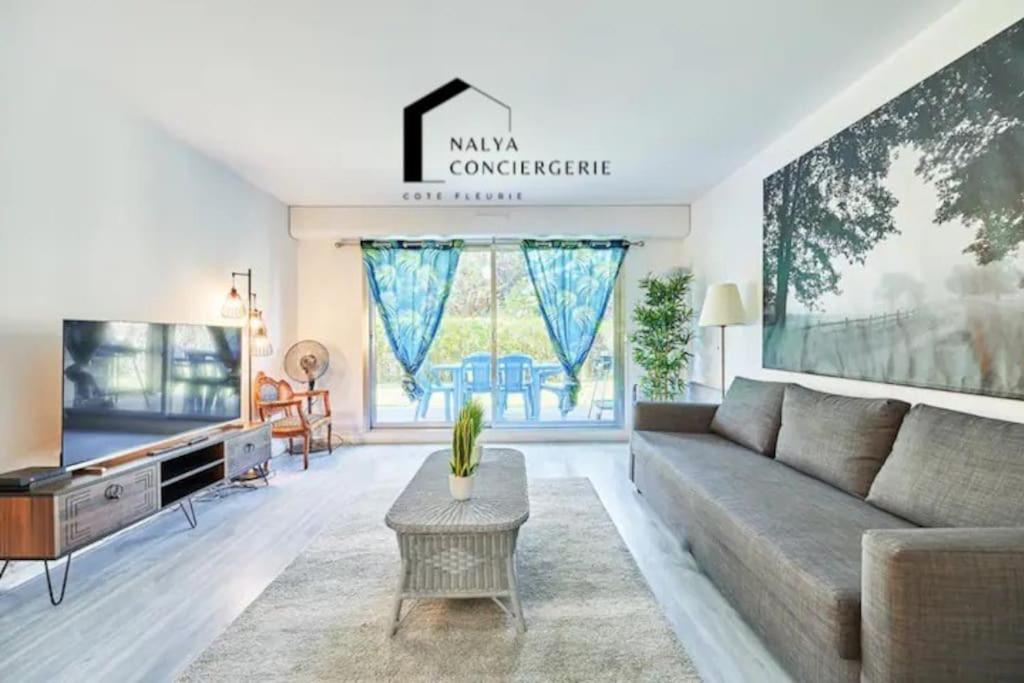 un salon avec un canapé et une télévision dans l'établissement Charming 2BR Private garden, 5MinToBeach Deauville, à Deauville