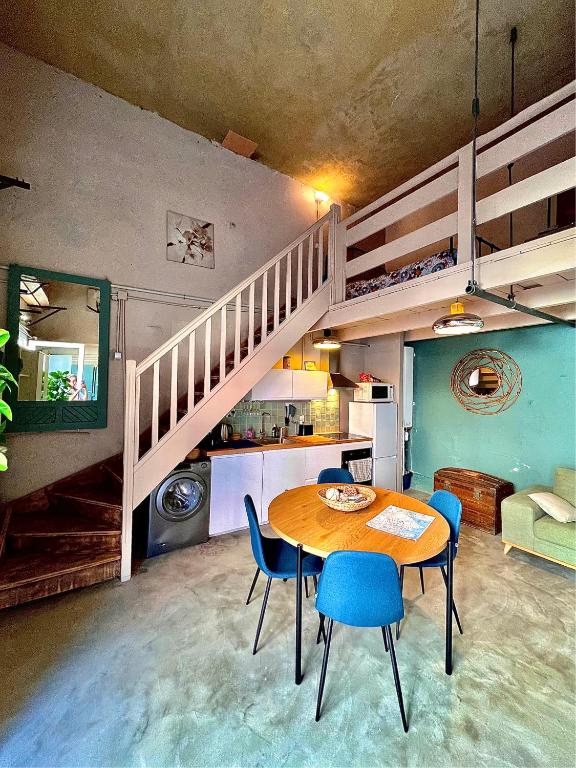 une salle à manger avec une table et des chaises et un escalier dans l'établissement Atypique et Charmant Nid Urbain, à Marseille