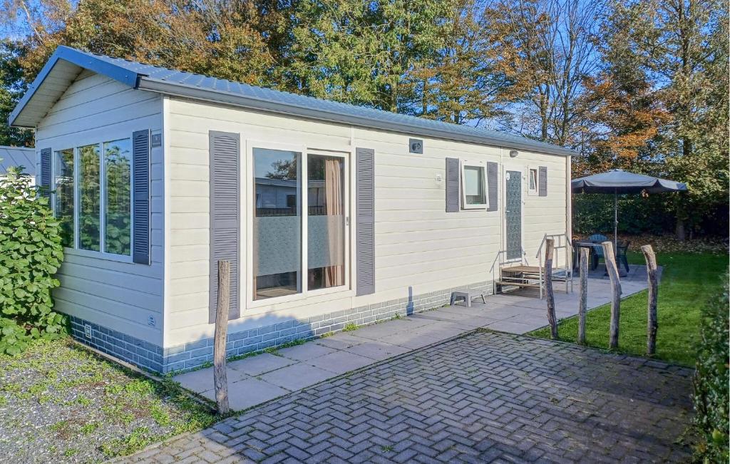 una piccola casa bianca con un patio di Pet Friendly Home In Heinkenszand a heinkenszand