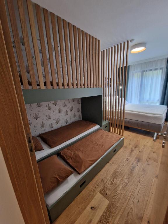 a bedroom with a bunk bed with wooden walls at Apartmán Ski & Bike Janské Lázně in Janske Lazne