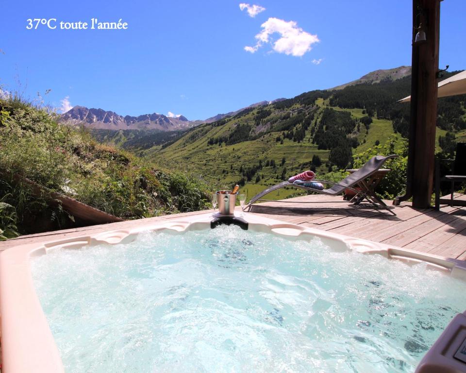d'un bain à remous avec un robinet et une montagne. dans l'établissement Prestigious Chalet with Pool & Hot tub, Mountain Views for 19 Guests, à Vars