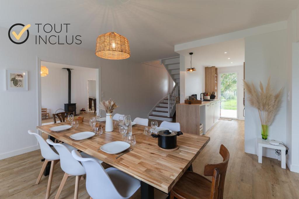 a dining room with a wooden table and white chairs at TY MEZOU - Jolie maison au bord du GR34 proche mer in Porspoder
