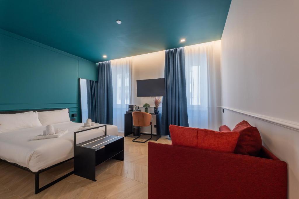 a bedroom with a bed and a red couch at Maria Cristina Boutique Rooms in Trieste