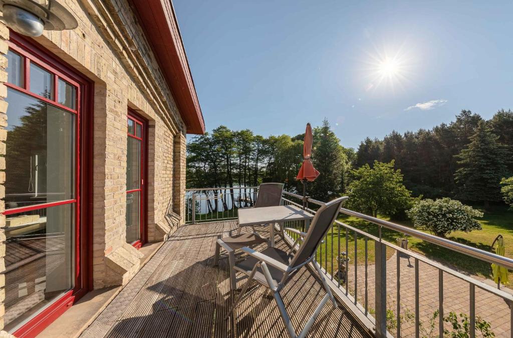JabelにあるZwergtaucher - Ferienwohnung mit Balkon, Seeblick & Freizeitangeboten am Seeの家の脇に椅子付きのデッキ