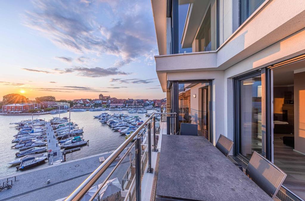 Un balcón con vista a un puerto deportivo con barcos. en Auszeit, Yoga-Apartment mit Kamin & Balkon in der Hafenresidenz, en Waren