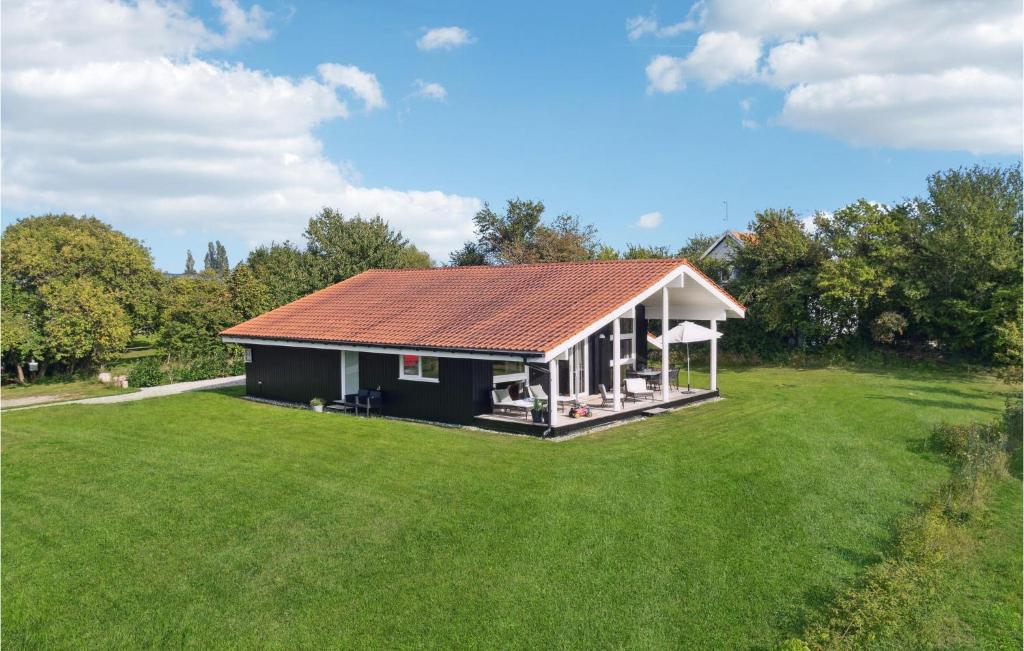 a small house with a large grass yard at Three-Bedroom Holiday Home In Askeby in Askeby