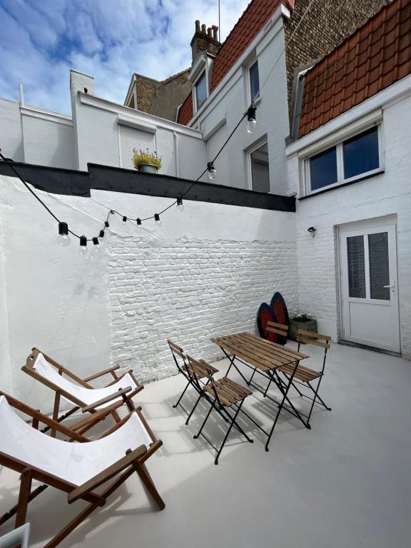 - une terrasse avec 2 chaises, une table et des chaises dans l'établissement Maison plein cœur de Malo-les-Bains - Proximité plage et commerces, à Dunkerque