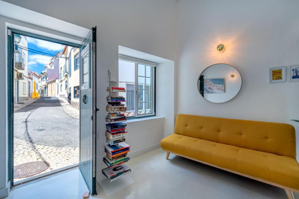 a living room with a yellow couch and books at Casa Pescador in Alvor in Alvor
