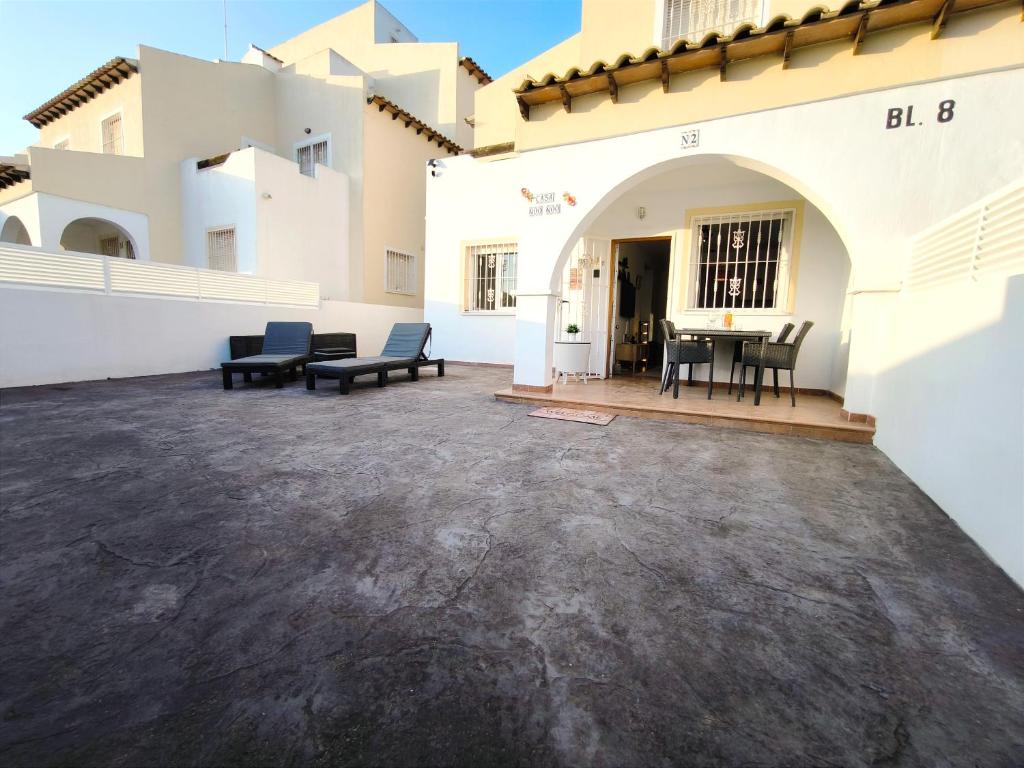 un patio con sedie e un tavolo in un edificio di Panorama Golf, Villa Martn semi-detached duplex a Villacosta