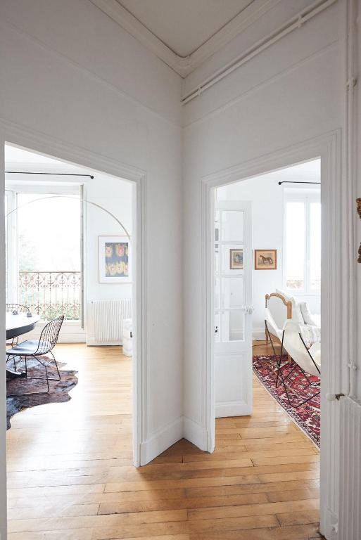 - un salon aux murs blancs avec une table et des chaises dans l'établissement Suite haussmannienne en Sologne, à Vierzon