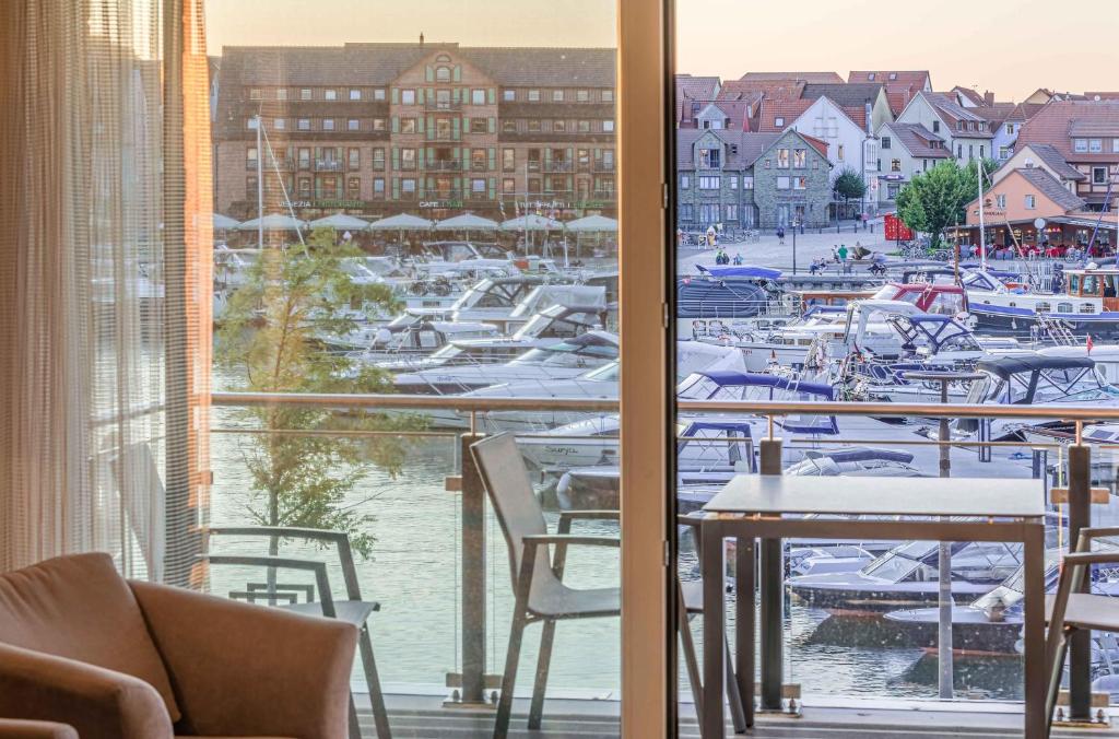 a room with a view of a marina with boats at Hafenidylle - Apartment in der Hafenresidenz mit Balkon & Wellness in Waren