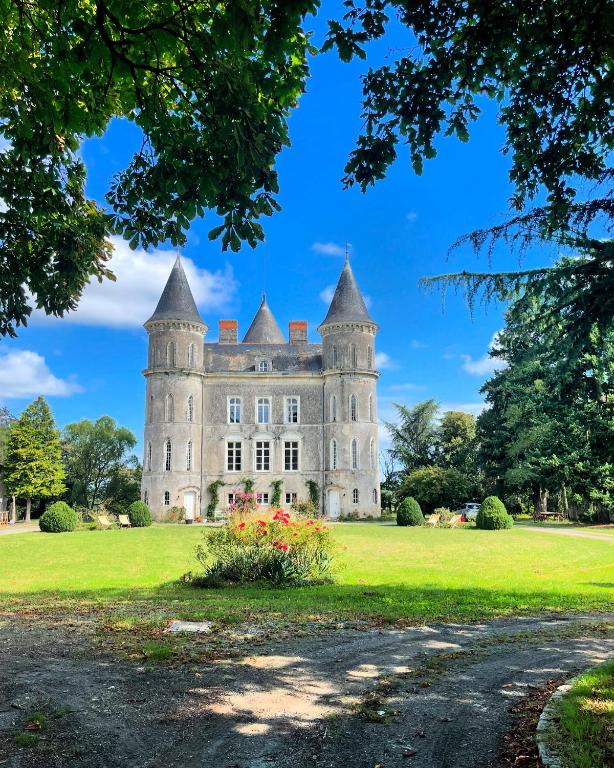 un vieux château sur un champ verdoyant avec des arbres dans l'établissement Château Doré les Tours - Appartement Loup, à Montfaucon
