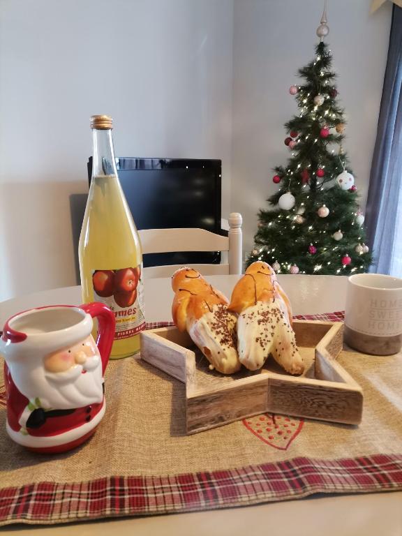 une table avec un arbre de Noël et un plateau de pâtisseries dans l'établissement Appartement 2 pièces Obernai proche centre ville, à Obernai
