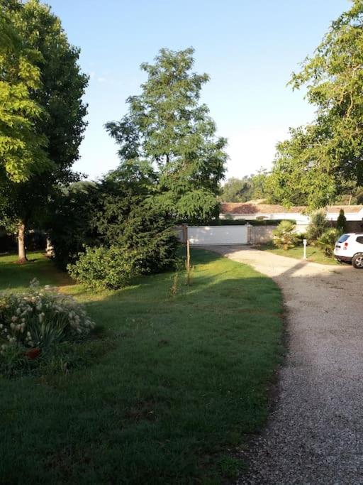 une cour herbeuse avec une voiture garée à côté d'une allée. dans l'établissement un coin tranquille, aux Mathes