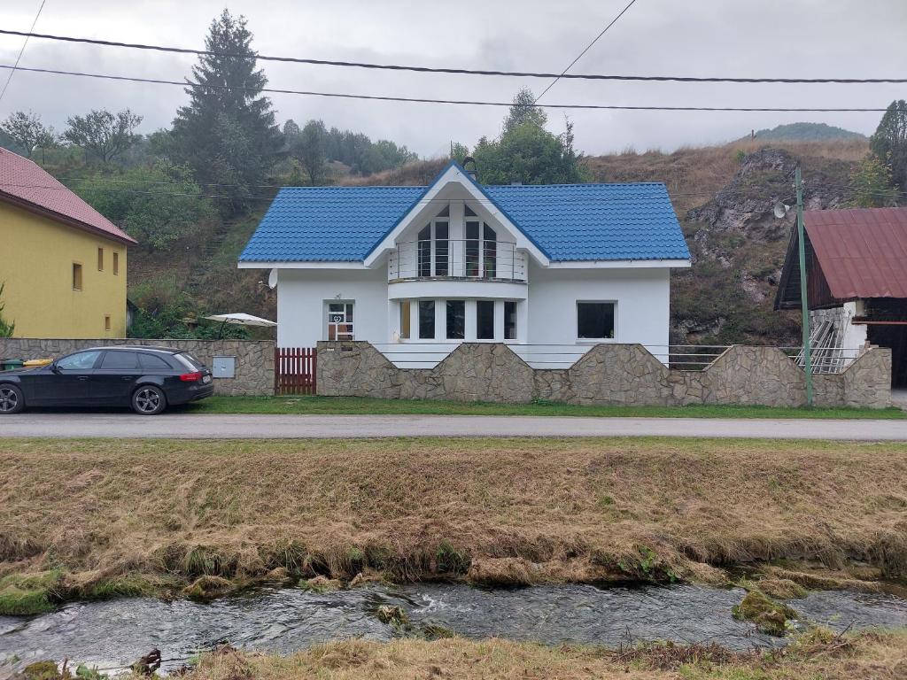 a white house with a blue roof at 3izbový rodinný dom s krbom in Ružomberok