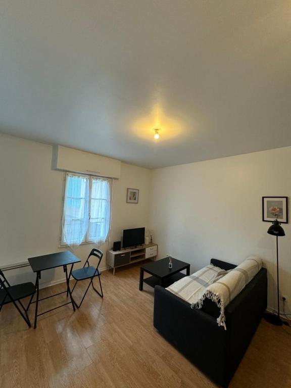 a living room with a couch and a table at Studio idéal Gare & Centre-Ville in Conflans-Sainte-Honorine