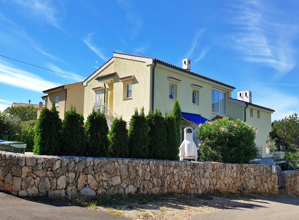 dom za kamienną ścianą w obiekcie Apartments Savic w mieście Šilo