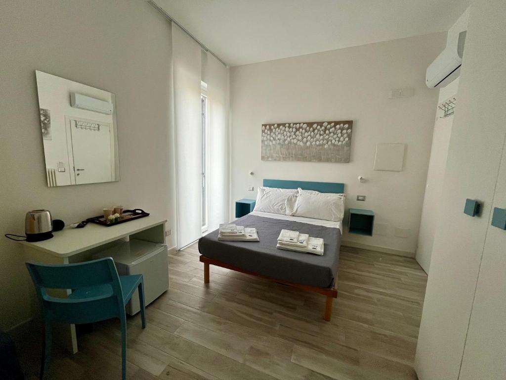 a bedroom with a bed and a desk and a bed and a table at Prospettiva Medina in Naples