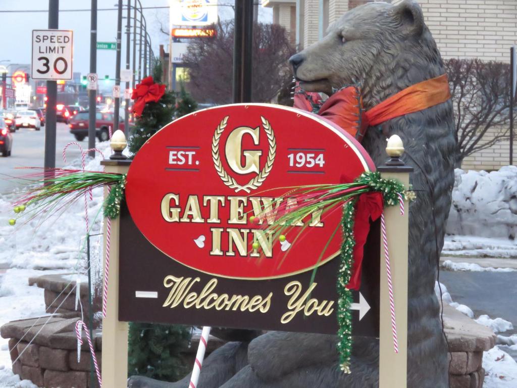 Uma estátua de um urso segurando um sinal para a estalagem. em Gateway Inn em Chicago