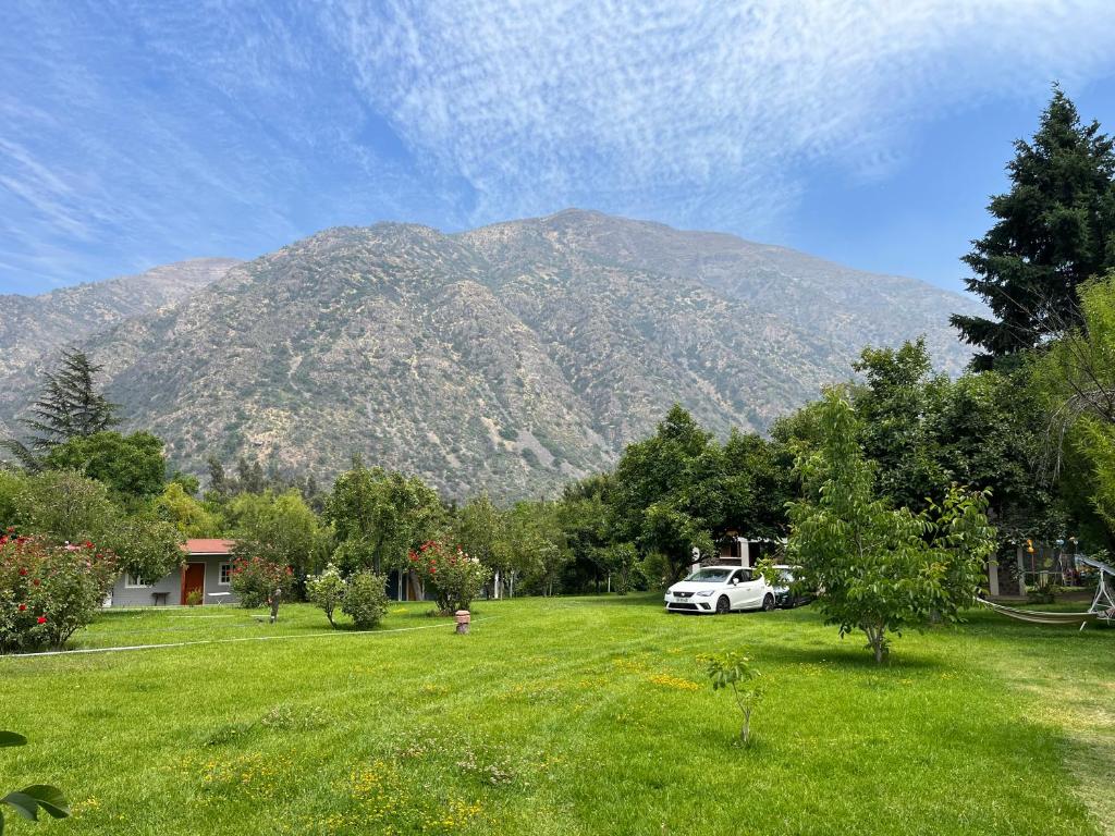 a car parked in a yard with a mountain in the background at Campito Refugio in San José de Maipo