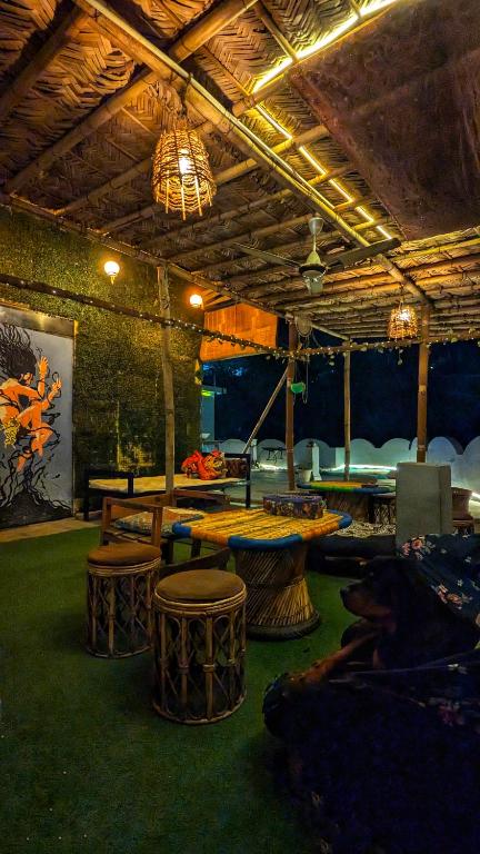 a room with tables and stools in a room at Hobbit House Hostel in Rishīkesh