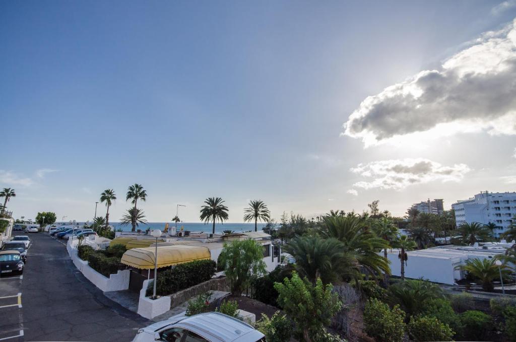 a view of a street with palm trees and the ocean at Terraced 2 bedroom beach rental in Maspalomas