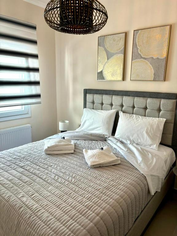 a bedroom with a large bed with two towels on it at JD family luxury apartment 1 in Volos