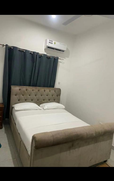 Fajara Heights في سيريكوندا: سرير في غرفة بيضاء مع