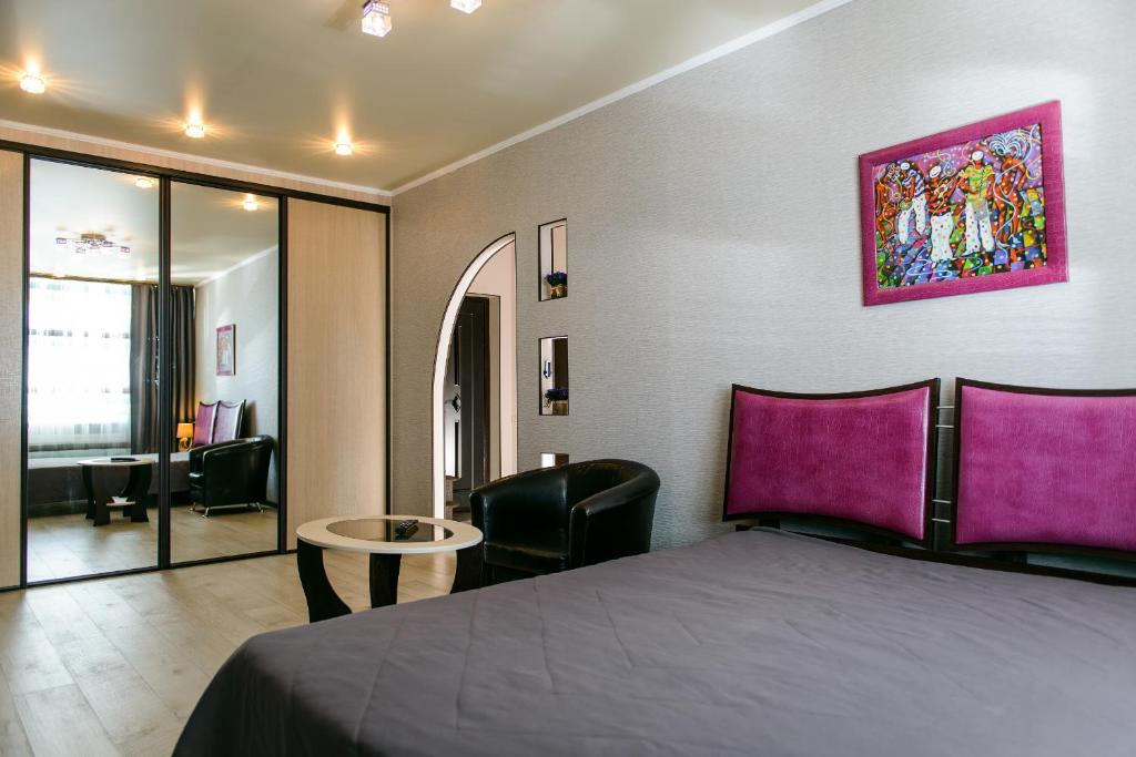 スィクティフカルにあるKosmos Apartmentsのベッドルーム1室(ベッド1台、テーブル付)、