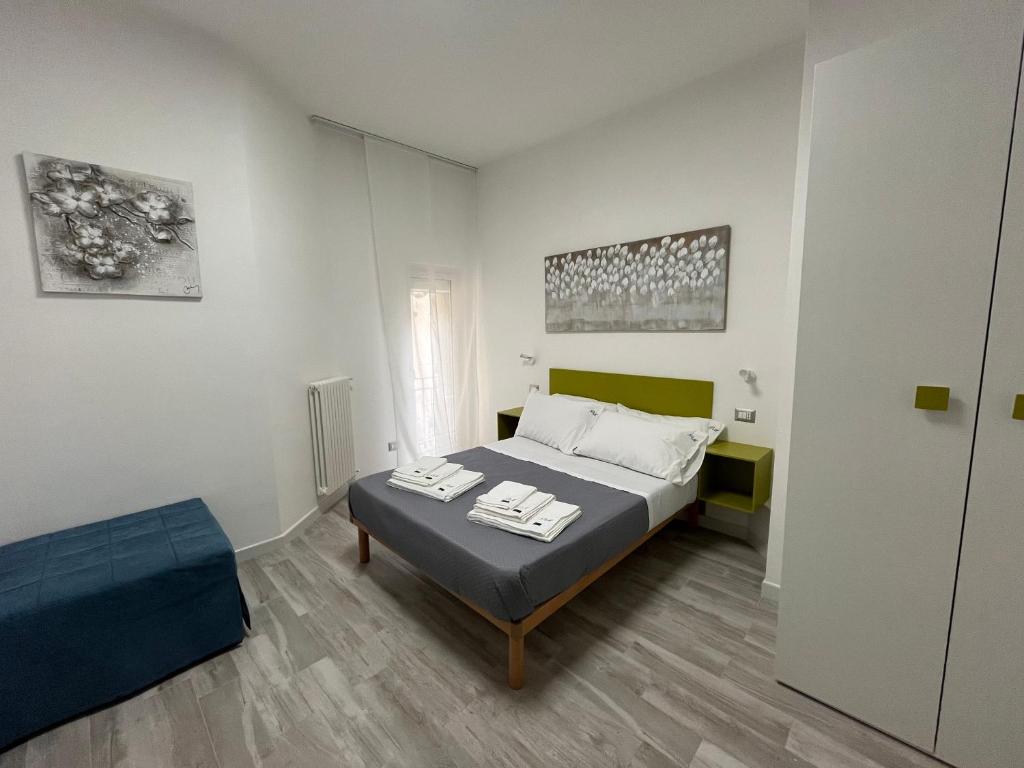 a white bedroom with a bed and a chair at Prospettiva Medina in Naples