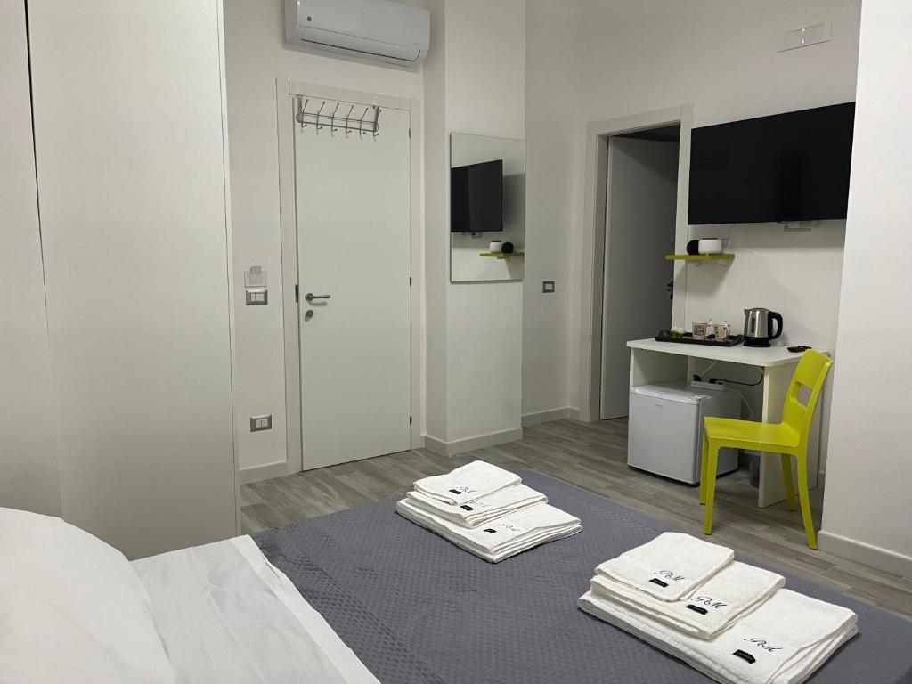 a room with a bed with a table and a yellow chair at Prospettiva Medina in Naples