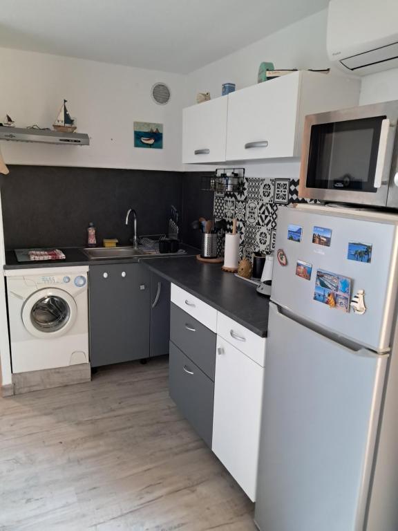 une cuisine avec un réfrigérateur et une machine à laver dans l'établissement Studio 2 personnes proche des plages et commerces, à La Seyne-sur-Mer