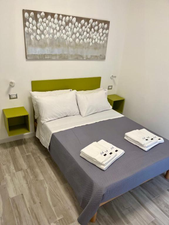 a bedroom with a bed with two towels on it at Prospettiva Medina in Naples
