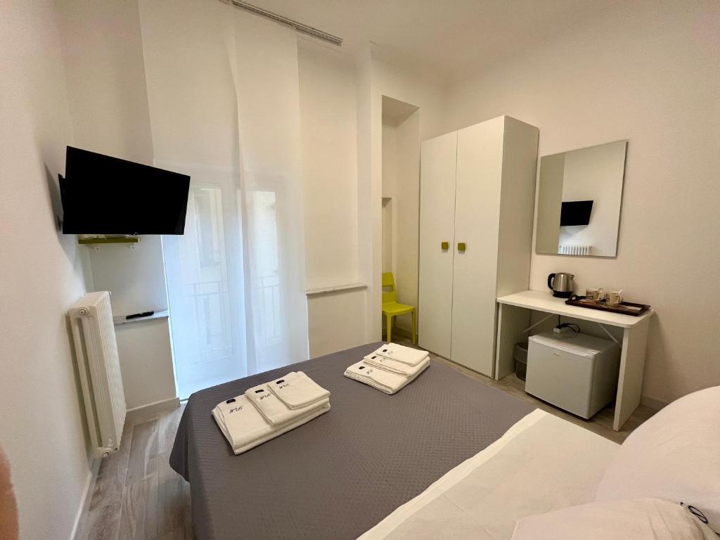 a small white room with a bed and a desk at Prospettiva Medina in Naples