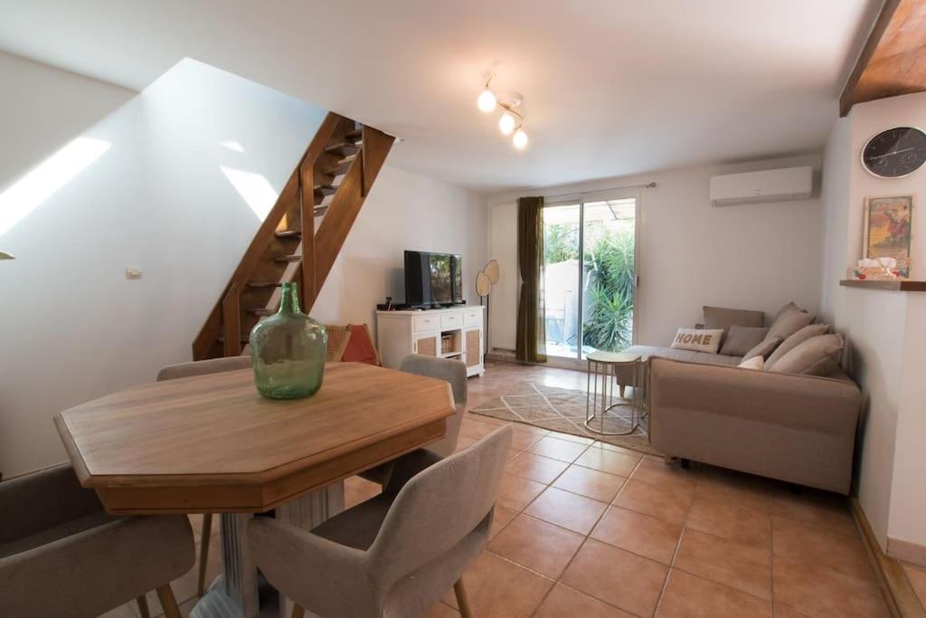 a living room with a table and a couch at Fé Di Biou - Jardin Parking Clim in Arles