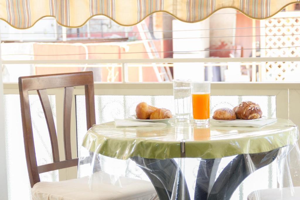 een tafel met een bord eten en een glas sinaasappelsap bij Jordan Home FREE CONCIERG SERVICE in Napels